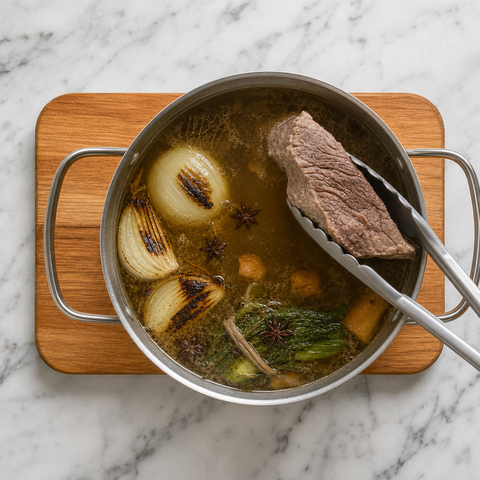 Caldo claro y aromático de ternera cociendo suavemente con pecho de res tierno