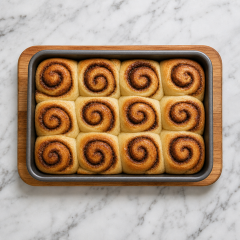 Freshly baked golden cinnamon rolls in a rectangular pan.