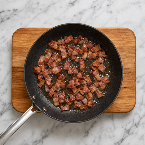 Bacon browning in a skillet for maple baked beans