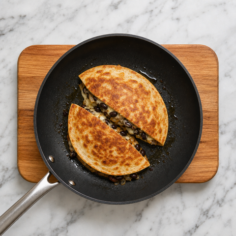 Quesadillas dorate che diventano croccanti in padella con il formaggio fuso
