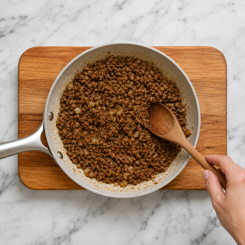 Minced beef browning with onion and paprika in a skillet