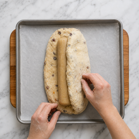 Stollen dough folded over a log of marzipan before baking