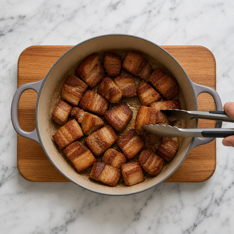 Pork belly cubes browned in a heavy pot