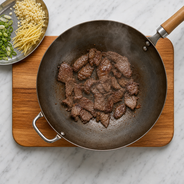 Beef slices searing until browned in a hot wok